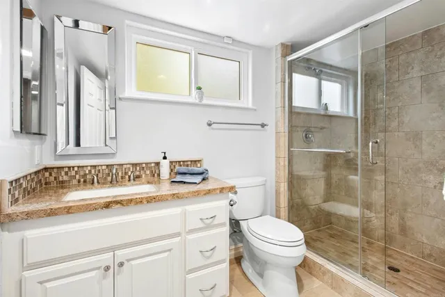 a bathroom with a sink a toilet and shower