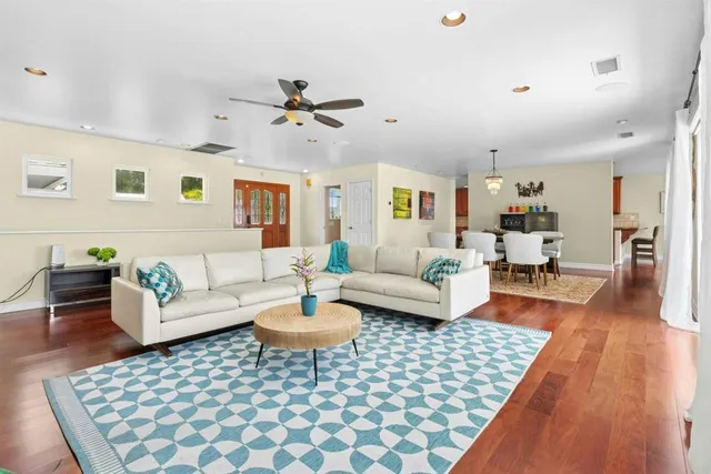 a living room with furniture and wooden floor