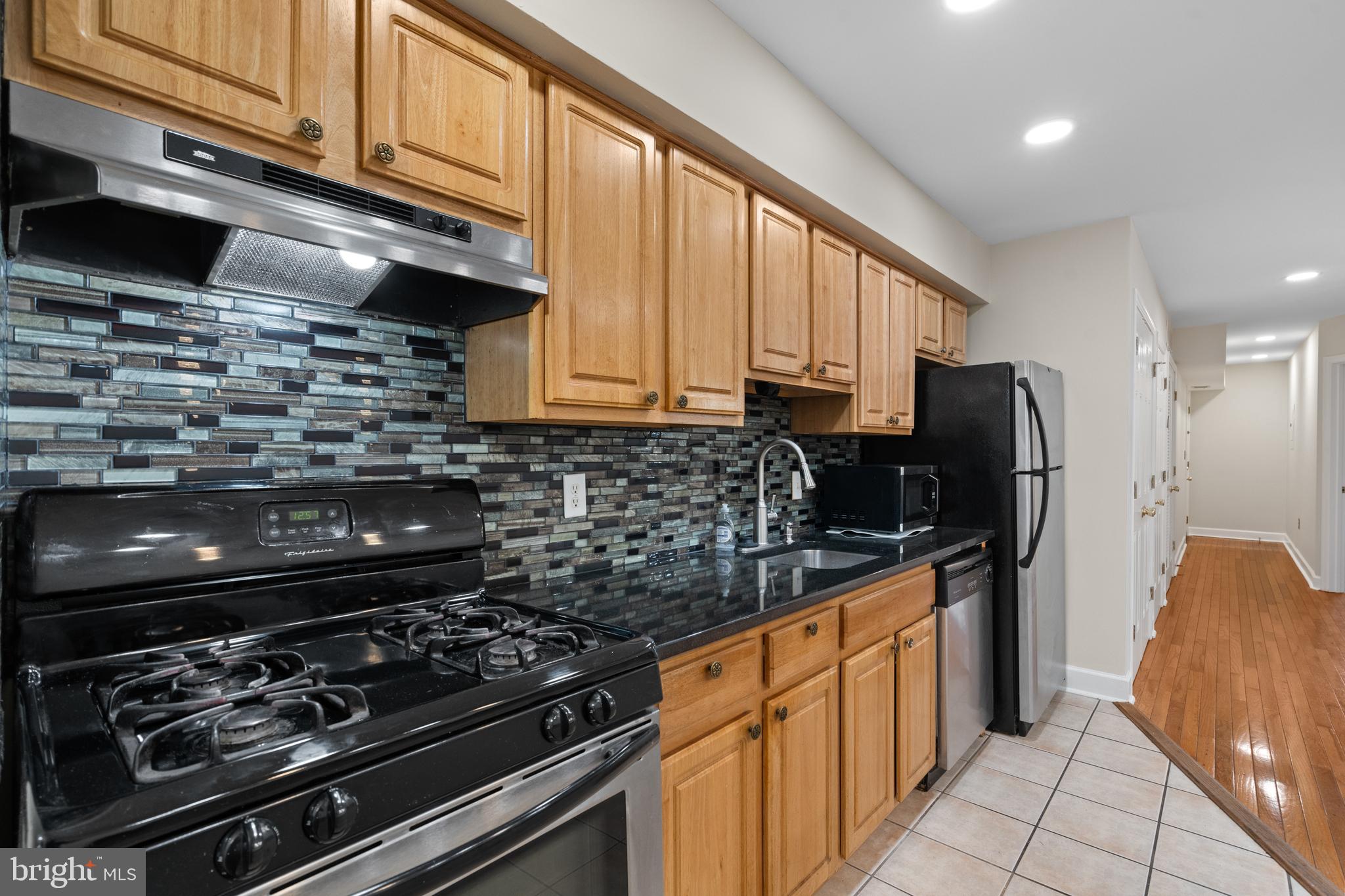 1909 Rosedale Street Northeast, Unit 3 Washington, DC 20002 - Photo 11 of 23 a kitchen with stainless steel appliances granite countertop a stove and a refrigerator