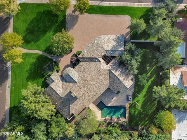 an aerial view of a house with a yard and a large tree