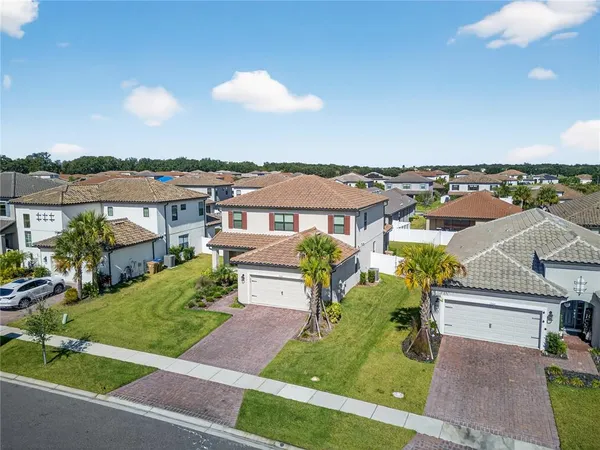 an aerial view of residential houses with outdoor space and trees
