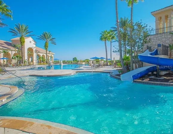 a view of a swimming pool with a yard and plants