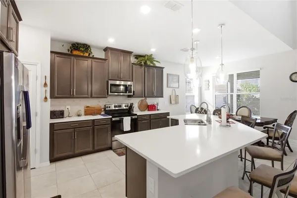 a kitchen with granite countertop a sink a counter top space appliances and cabinets