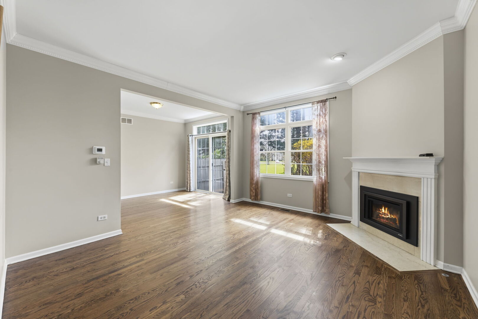 1728 Pershing Avenue, Unit 3 Wheaton, IL 60189 - Photo 4 of 32 a view of an empty room with wooden floor fireplace and a window