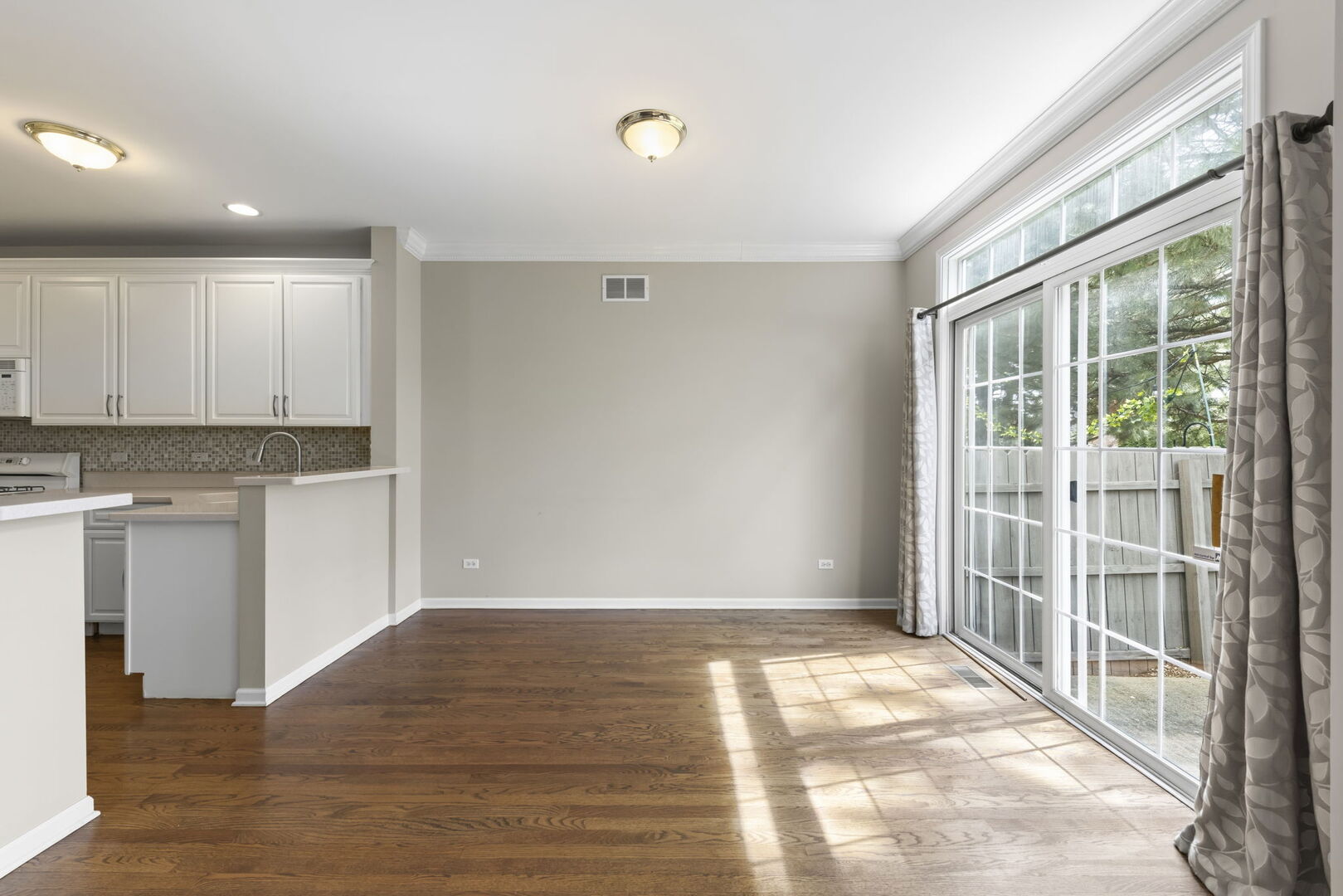 1728 Pershing Avenue, Unit 3 Wheaton, IL 60189 - Photo 7 of 32 a view of an empty room with wooden floor and a window