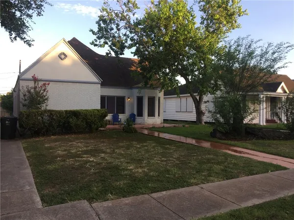 a front view of a house with a yard and trees