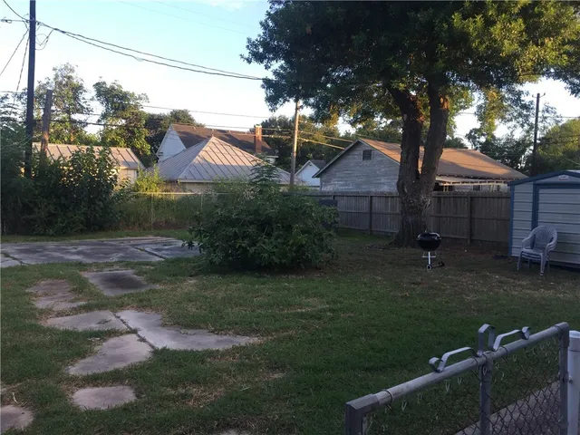 a view of a backyard with a tub and wooden fence