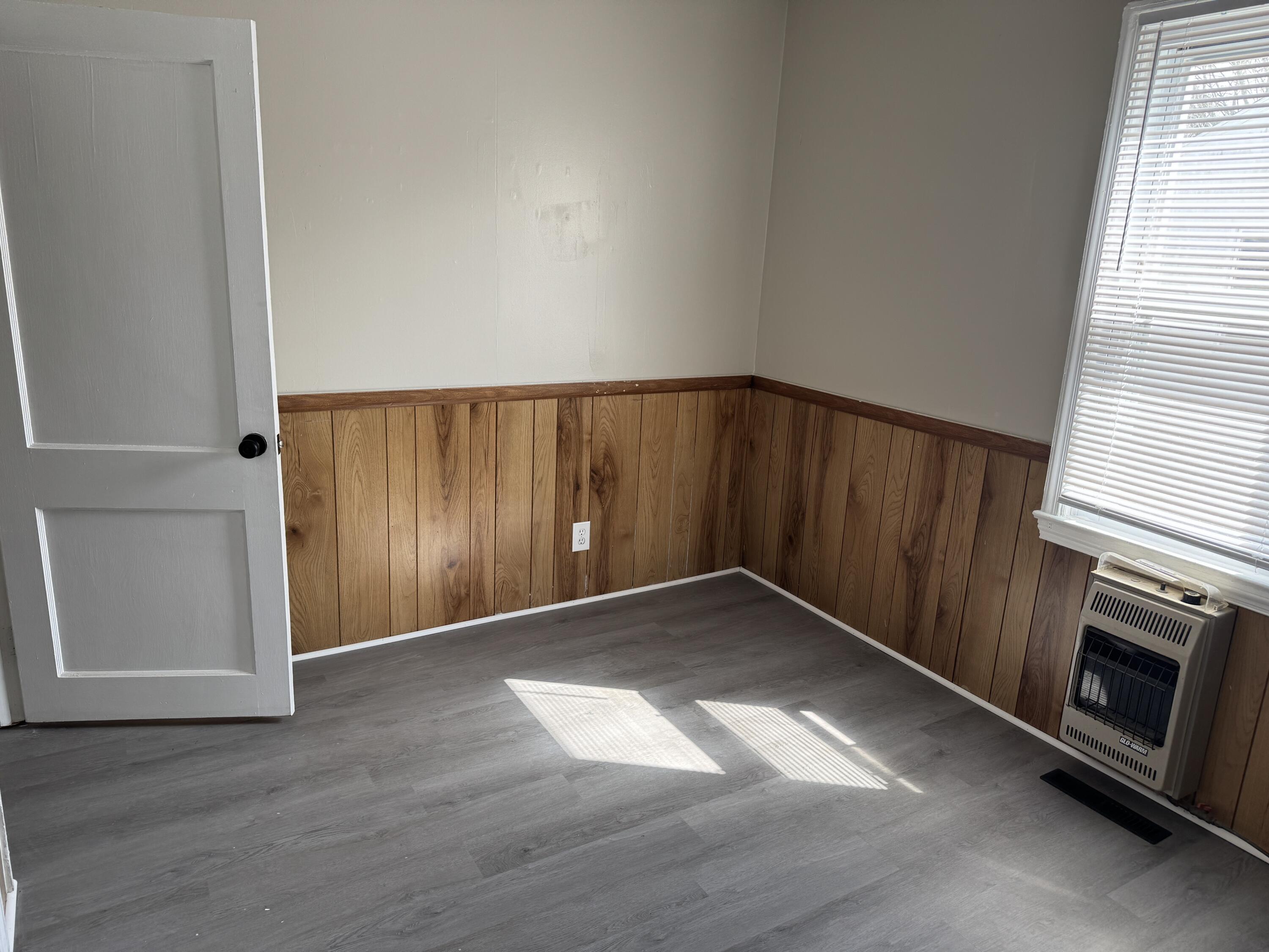 125 Elam Drive Ridgeway, VA 24148 - Photo 6 of 10 an empty room with wooden floor fireplace and windows