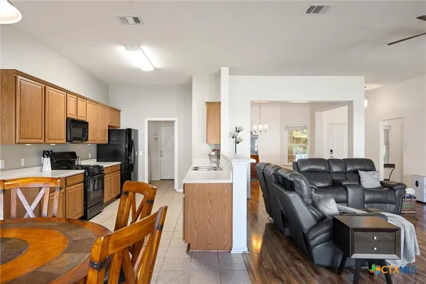 a living room with furniture a flat screen tv and kitchen view