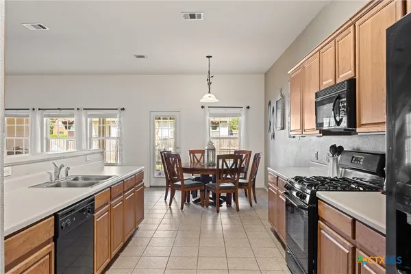 a kitchen with granite countertop a sink stove and cabinets