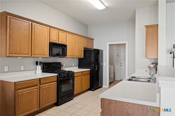 a kitchen with stainless steel appliances granite countertop a refrigerator stove microwave sink and cabinets