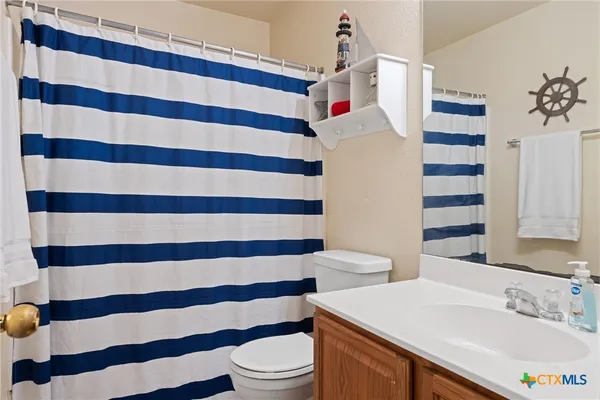 a bathroom with a sink and mirror with toilet