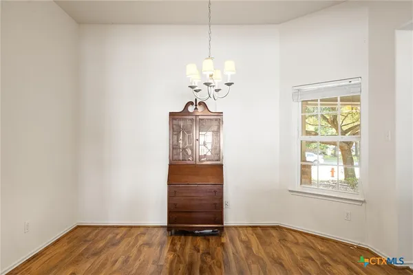 a view of a room with wooden floor chandelier and closet