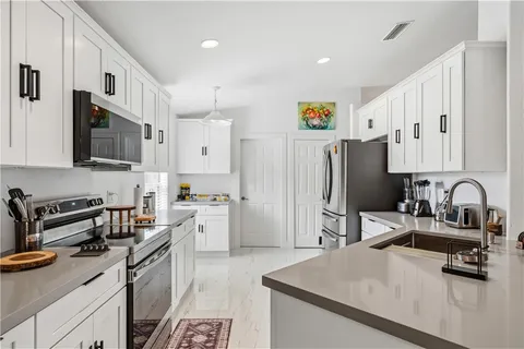 a kitchen with stainless steel appliances granite countertop a sink stove and refrigerator