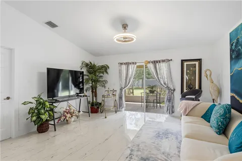 a living room with furniture potted plant and a large window
