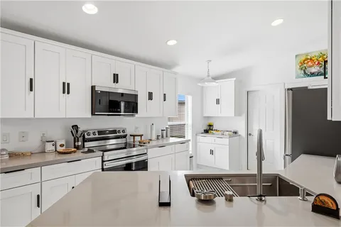 a kitchen with stainless steel appliances a stove a sink and cabinets