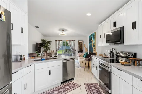a kitchen with a sink stainless steel appliances and white cabinets