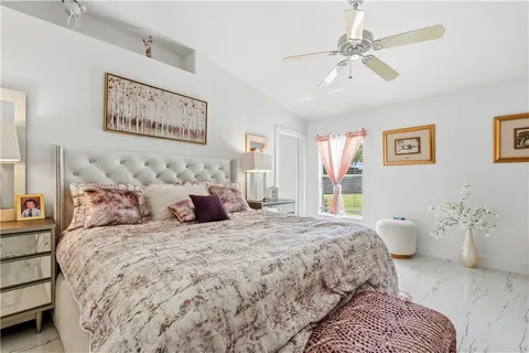 a bedroom with a large bed and a chandelier
