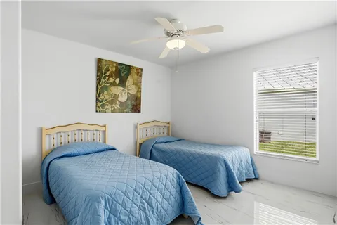 a bedroom with two beds and a window