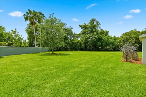 a view of green field with trees in the background