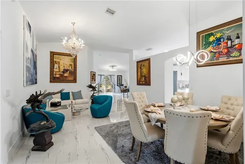 a living room with furniture and paintings on the wall