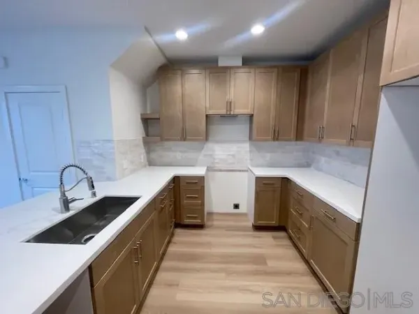 a kitchen with kitchen island granite countertop a sink stainless steel appliances and cabinets