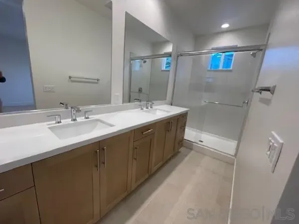 a spacious bathroom with a sink double vanity granite tub shower and a mirror