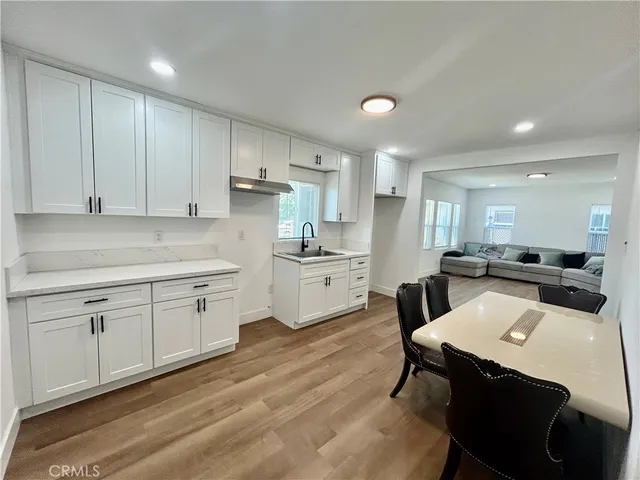 a kitchen with a sink cabinets and wooden floor