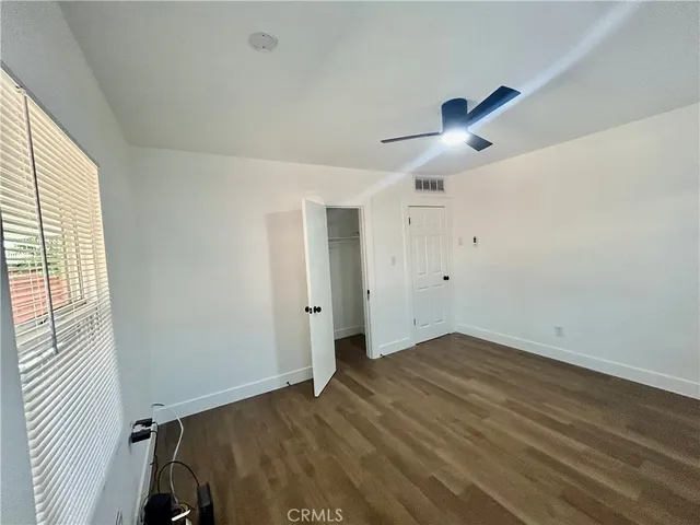 an empty room with a window and a ceiling fan