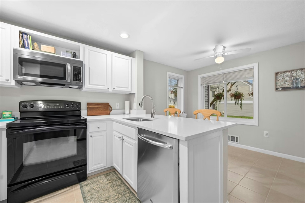151 Stone Ridge Road, Unit 151 Franklin, MA 02038 - Photo 15 of 39 a kitchen with stainless steel appliances a stove microwave and sink
