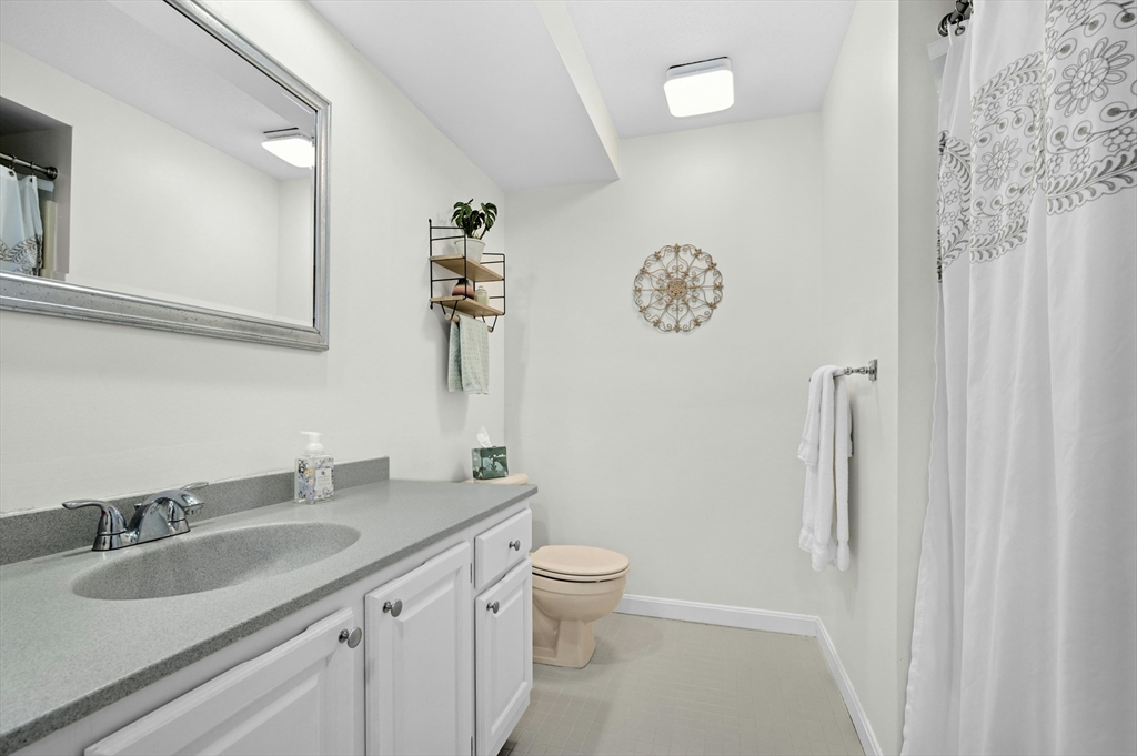 151 Stone Ridge Road, Unit 151 Franklin, MA 02038 - Photo 23 of 39 a bathroom with a granite countertop sink a toilet and a mirror
