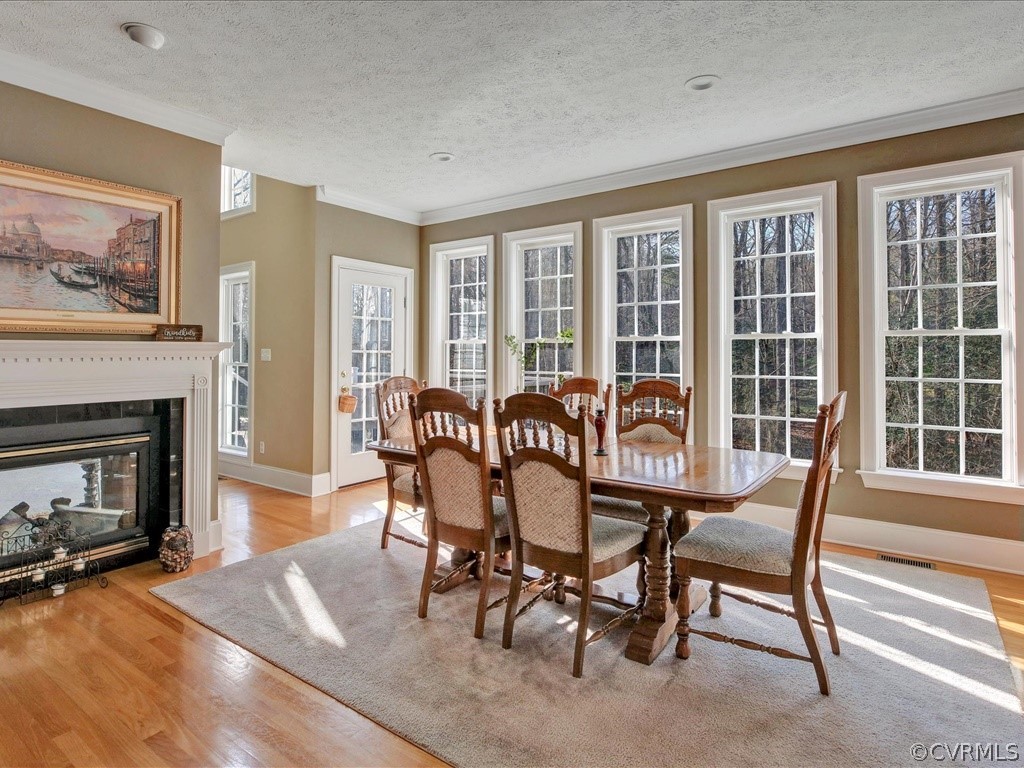 13711 Beechwood Point Road Midlothian, VA 23112 - Photo 10 of 49 a dining room with furniture a fireplace and wooden floor