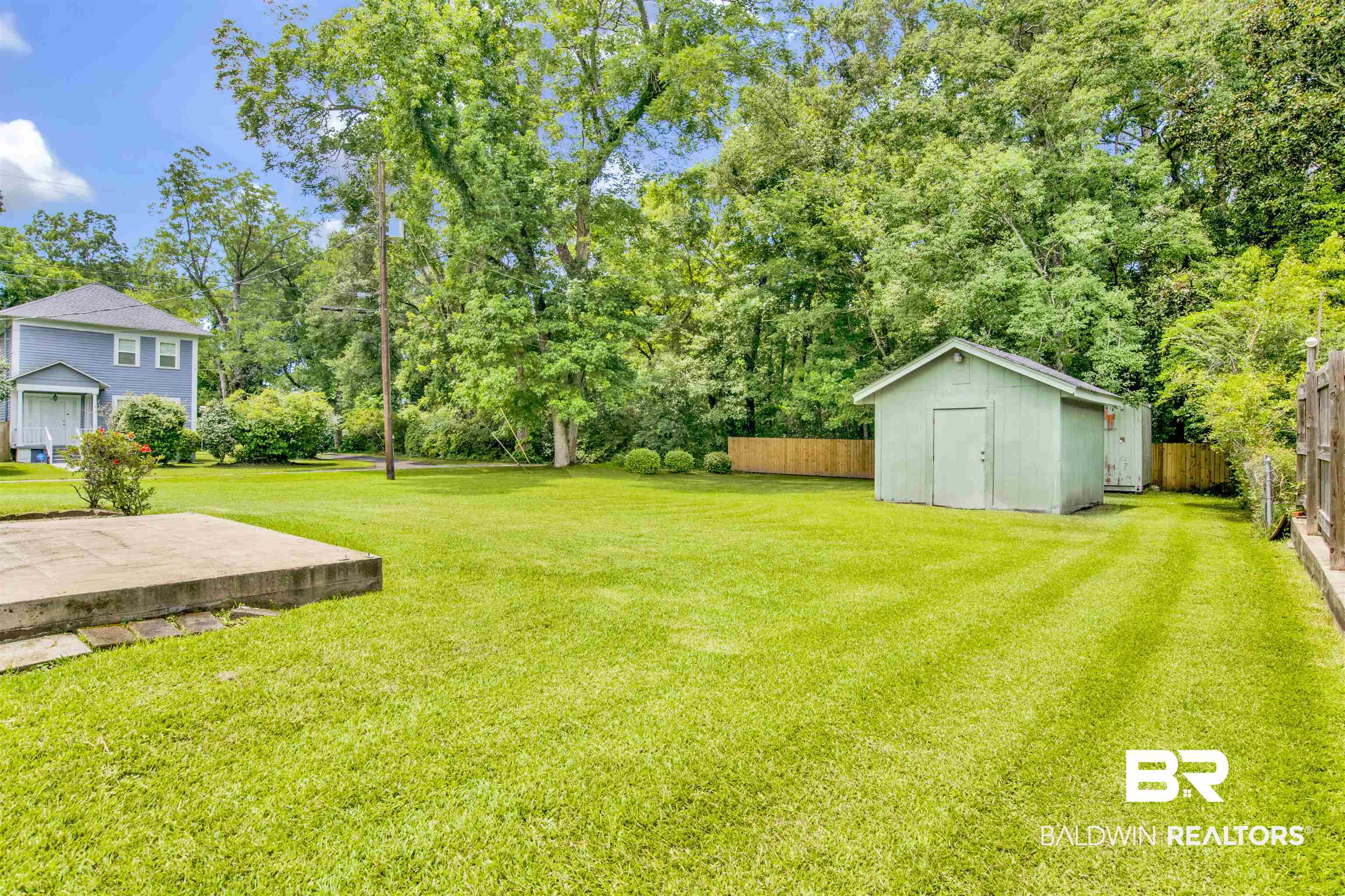 1476 Boudousquie Street Mobile, AL 36605 - Photo 25 of 34 View of yard featuring a storage unit and view of wooded area