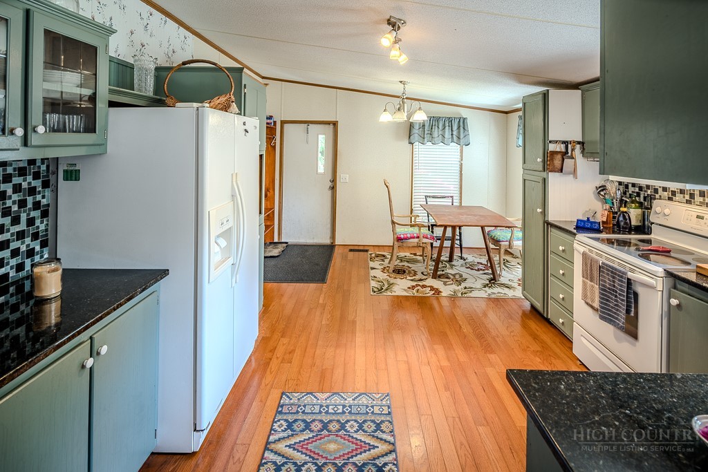 461 Reuben Wooten Road Banner Elk, NC 28604 - Photo 13 of 39 a kitchen with stainless steel appliances granite countertop a refrigerator a stove and a wooden floors