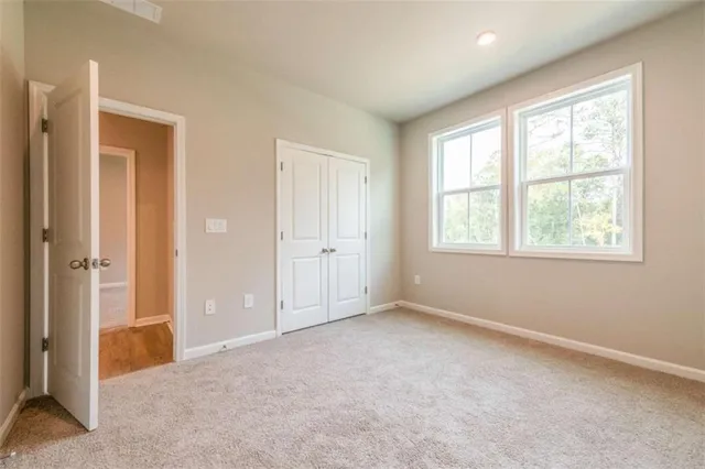 an empty room with windows and closet