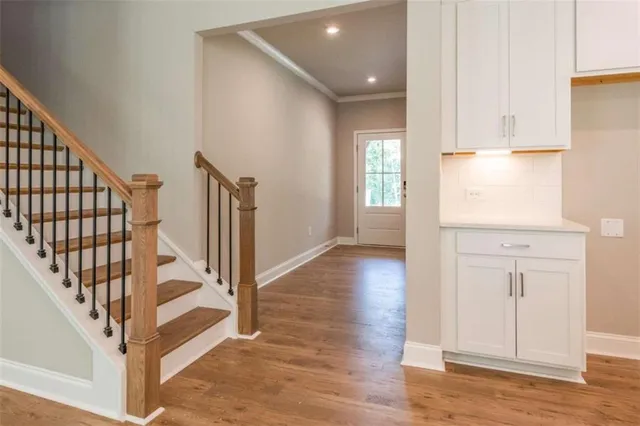 a view of a hallway with wooden floor and staircase
