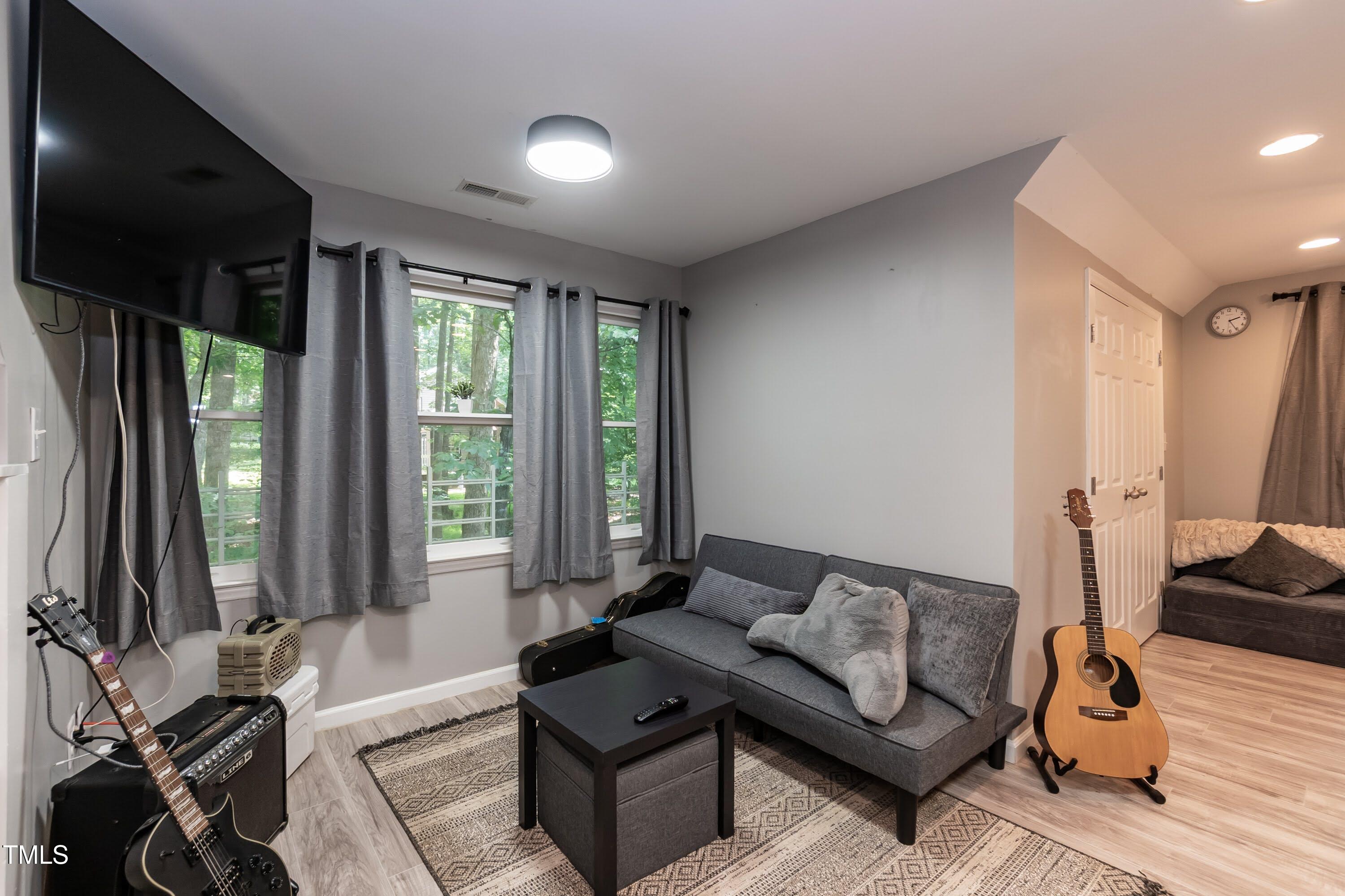 7216 Rabbit Run Wake Forest, NC 27587 - Photo 71 of 75 a living room with furniture and a flat screen tv