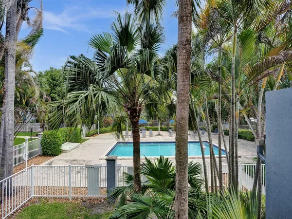a view of backyard of house with palm trees