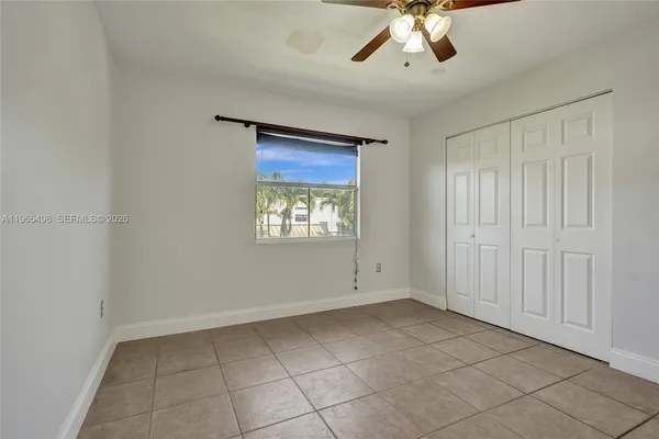 a view of an empty room and chandelier fan