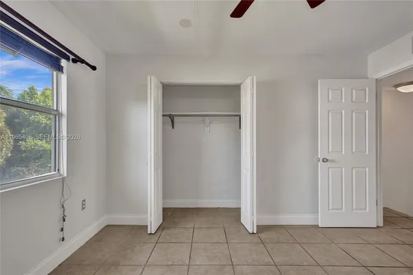 a view of an empty room with a ceiling fan