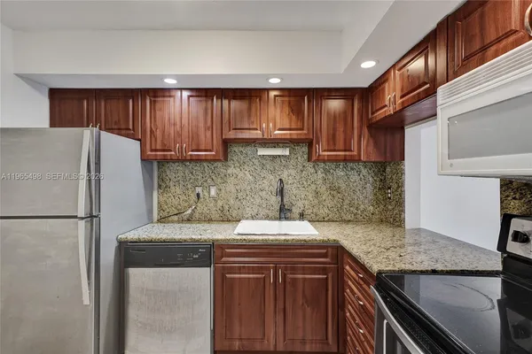 a kitchen with stainless steel appliances granite countertop a stove and a sink
