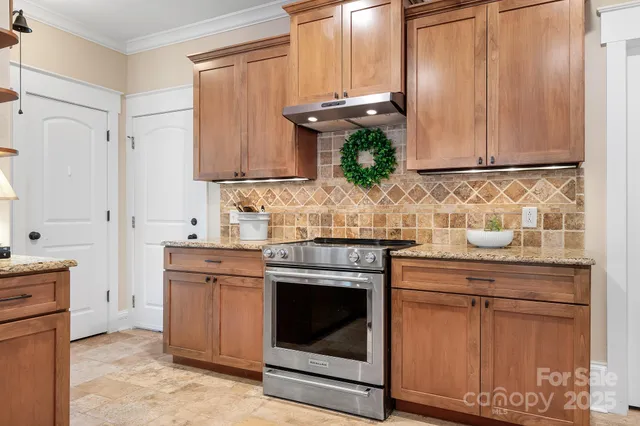 a kitchen with stainless steel appliances granite countertop a sink stove and cabinets