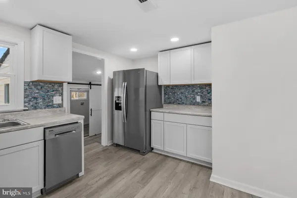 a kitchen with white cabinets and appliances