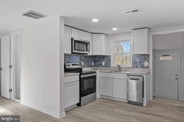a kitchen with white cabinets and stainless steel appliances