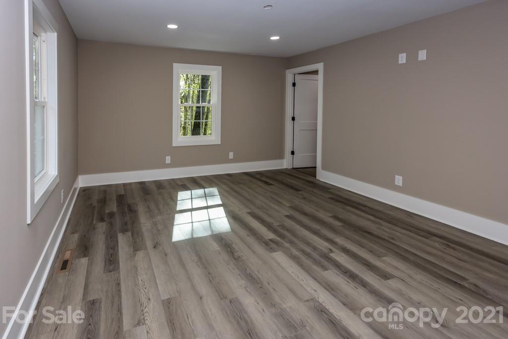 223 Hidden Hill Road Tryon, NC 28782 - Photo 14 of 27 an empty room with wooden floor and windows