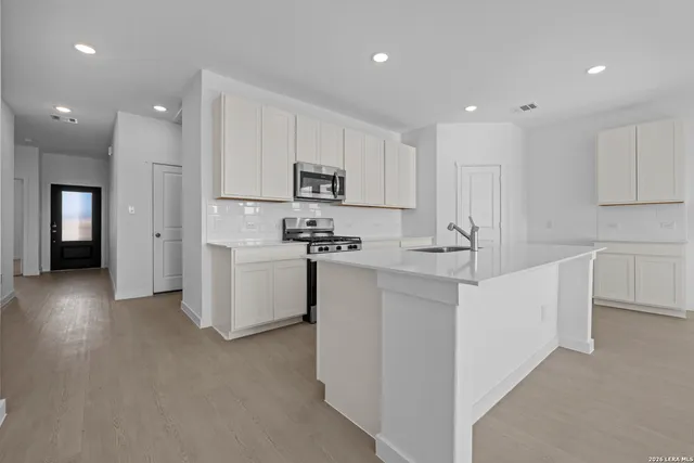 a kitchen with white cabinets and stainless steel appliances