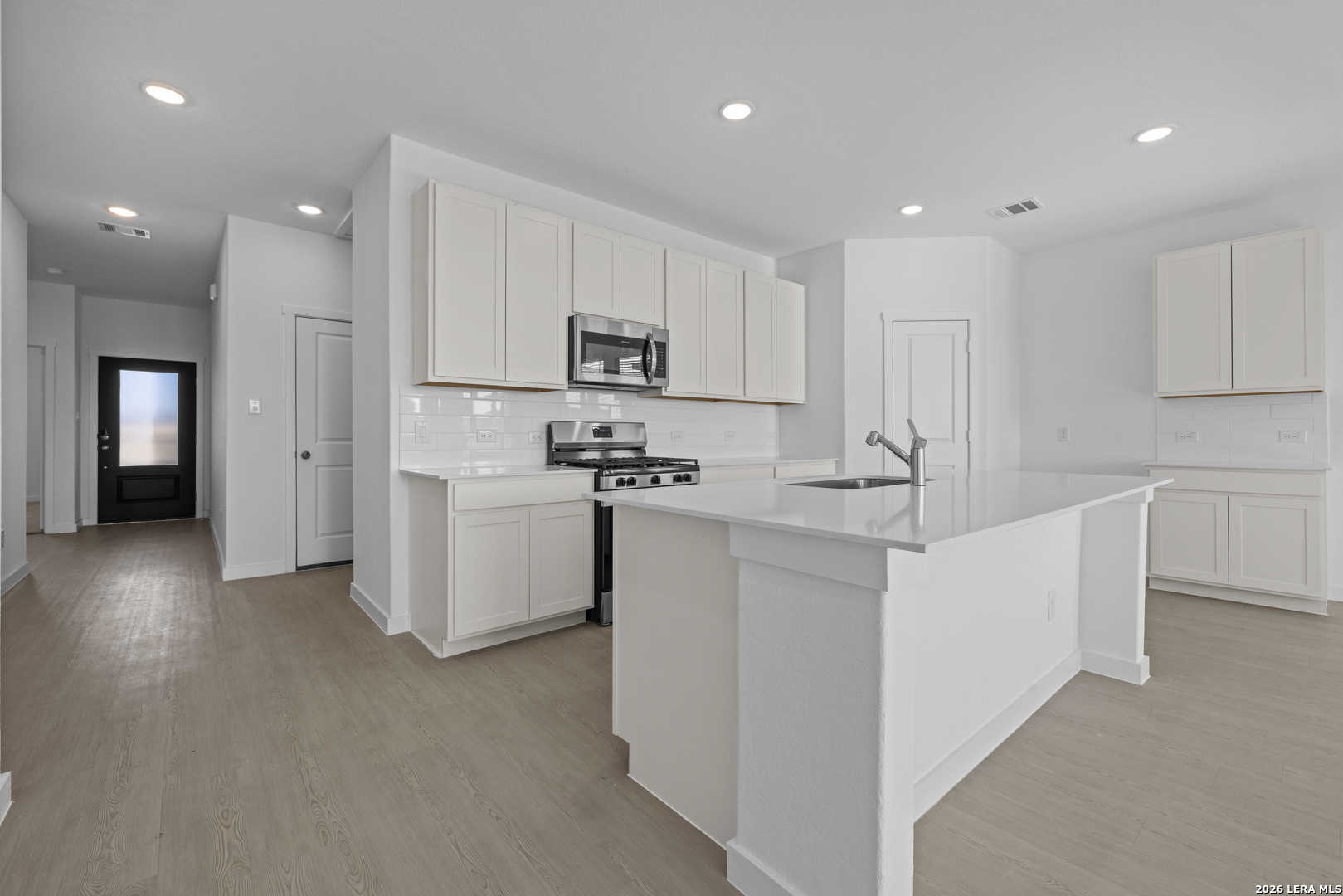 1895 Nuthatch Ridge New Braunfels, TX 78130 - Photo 4 of 20 a kitchen with white cabinets and stainless steel appliances