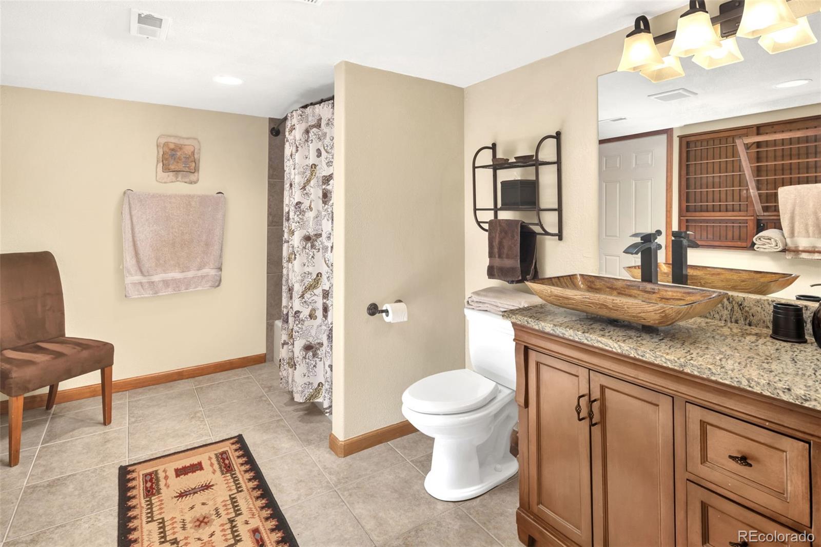 3816 Cloverleaf Drive Boulder, CO 80304 - Photo 26 of 35 a spacious bathroom with a granite countertop sink a toilet a mirror and shower