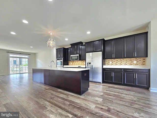 a large kitchen with wooden floors and wooden cabinets