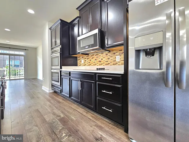 a kitchen with stainless steel appliances granite countertop a refrigerator and a sink